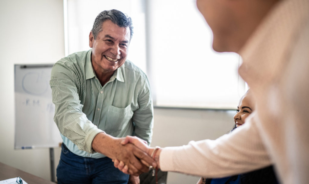 This image depicts a business owner shaking hands with a client.