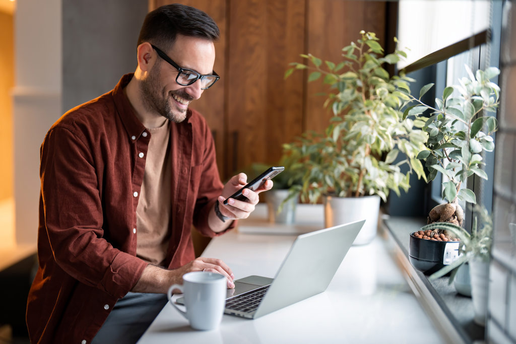 a man on phone in front of laptop