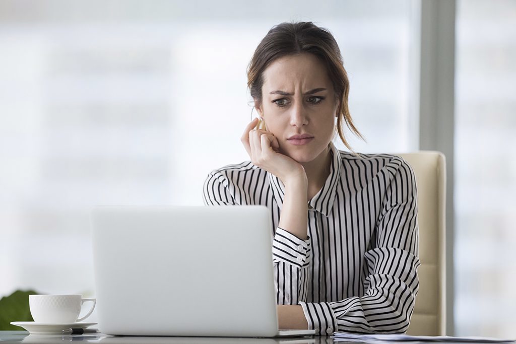 girl at laptop looking confused